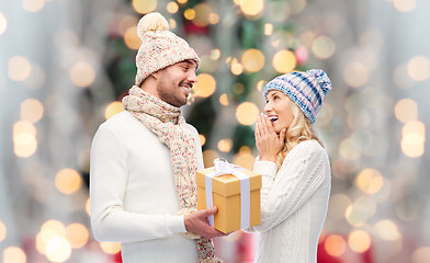 Image showing smiling couple in winter clothes with gift box