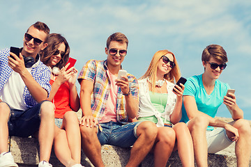 Image showing group of smiling friends with smartphones outdoors