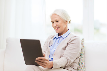 Image showing happy senior woman with tablet pc at home