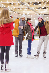 Image showing happy friends taking photo on skating rink