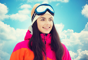 Image showing happy young woman in ski goggles over blue sky