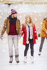 Image showing happy couple holding hands on skating rink