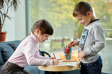 Image showing happy little girl and boy drawing at home