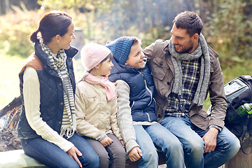 Image showing happy family sitting on bench and talking at camp