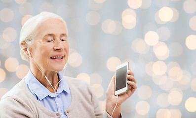 Image showing senior woman with smartphone and earphones