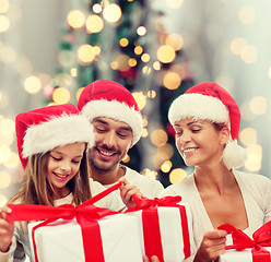 Image showing happy family in santa helper hats with gift boxes