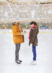 Image showing happy couple with engagement ring on skating rink