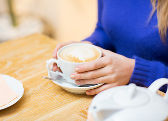 Image showing close up of woman with coffee cup at cafe