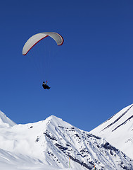 Image showing Paraglider in sunny snowy mountains at nice day