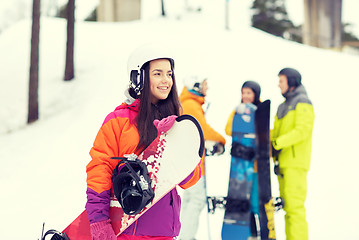 Image showing happy friends in helmets with snowboards