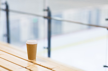 Image showing close up of coffee cup on bench at skating rink