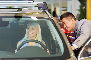 Image showing happy woman with car dealer in auto show or salon