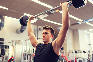 Image showing young man flexing muscles with barbell in gym