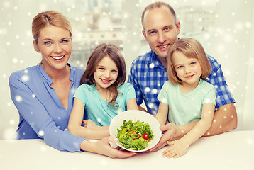 Image showing happy family with two kids showing salad in bowl
