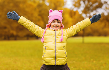 Image showing happy little girl with raised hands outdoors