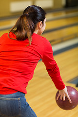 Image showing close up of woman throwing ball in bowling club