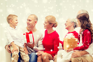 Image showing smiling family with gifts talking at home