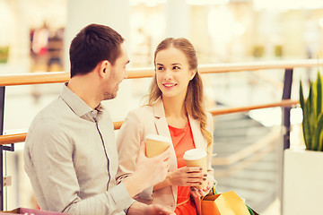 Image showing happy couple with shopping bags drinking coffee