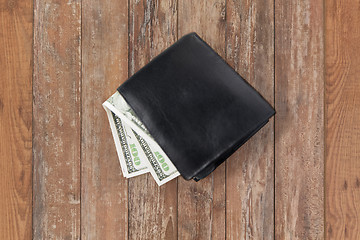 Image showing close up of dollar money in black wallet on table