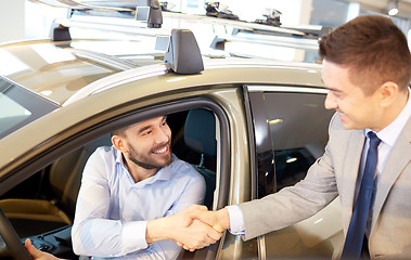 Image showing happy man with car dealer in auto show or salon