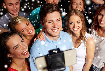 Image showing friends with smartphone taking selfie in club