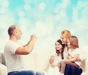 Image showing happy family with camera at home