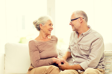 Image showing happy senior couple hugging on sofa at home