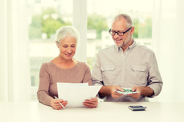 Image showing senior couple with money and calculator at home