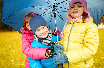 Image showing happy children with umbrella in autumn park