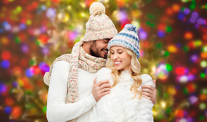 Image showing happy couple in winter clothes hugging over lights