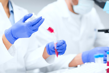 Image showing close up of scientists hands with test tube in lab