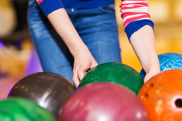 Image showing close up of woman hands choosing bowling ball