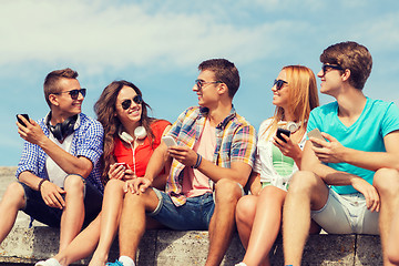 Image showing group of smiling friends with smartphones outdoors
