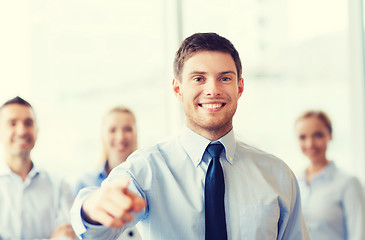 Image showing smiling businessman with colleagues in office