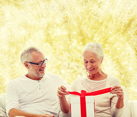 Image showing happy senior couple with gift box at home