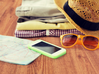 Image showing close up of summer clothes and travel map on floor