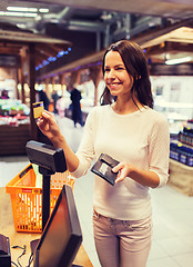 Image showing happy woman with credit card buying food in market