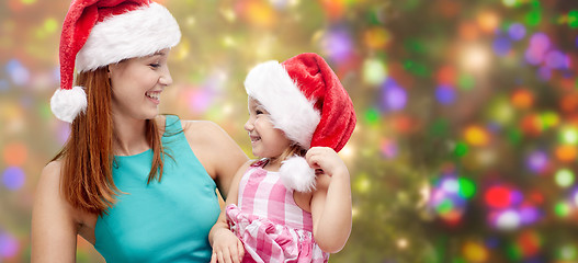 Image showing happy mother and little girl in santa hats