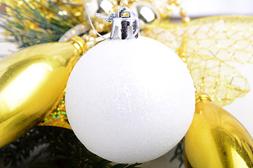 Image showing festive golden christmas decoration, candles, white balls, green fir tree branch, close up
