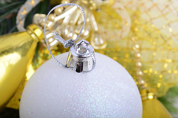 Image showing festive golden christmas decoration, candles, white balls, green fir tree branch, close up