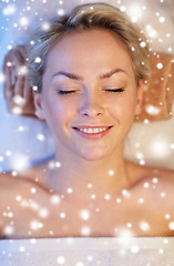 Image showing close up of smiling young woman lying in spa salon