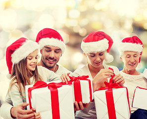 Image showing happy family in santa helper hats with gift boxes