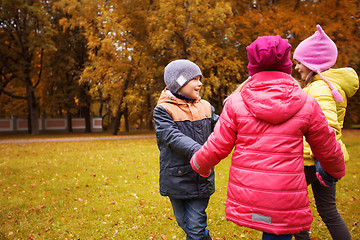 Image showing children holding hands and playing in autumn park