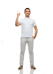 Image showing smiling man pointing finger up