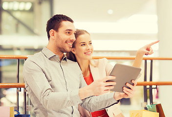 Image showing couple with tablet pc and shopping bags in mall