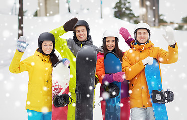 Image showing happy friends in helmets with snowboards