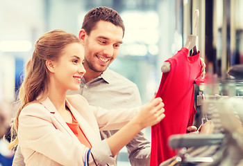 Image showing happy young couple choosing dress in mall