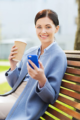 Image showing smiling woman with coffee and smartphone