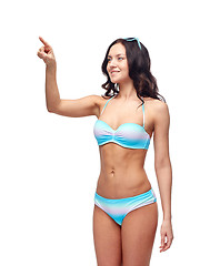 Image showing happy woman in bikini swimsuit pointing finger