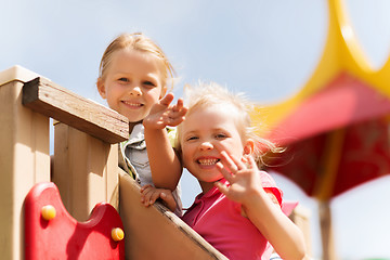 Image showing happy girls waving hands on children playground